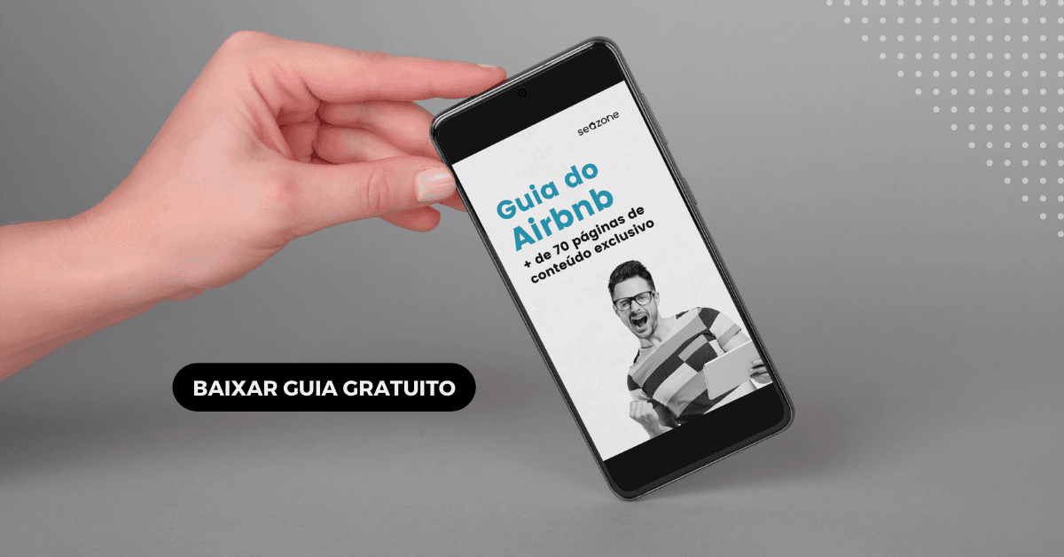 Mão segurando um smartphone que exibe a capa de uma guia de conteúdos exclusivos do Airbnb