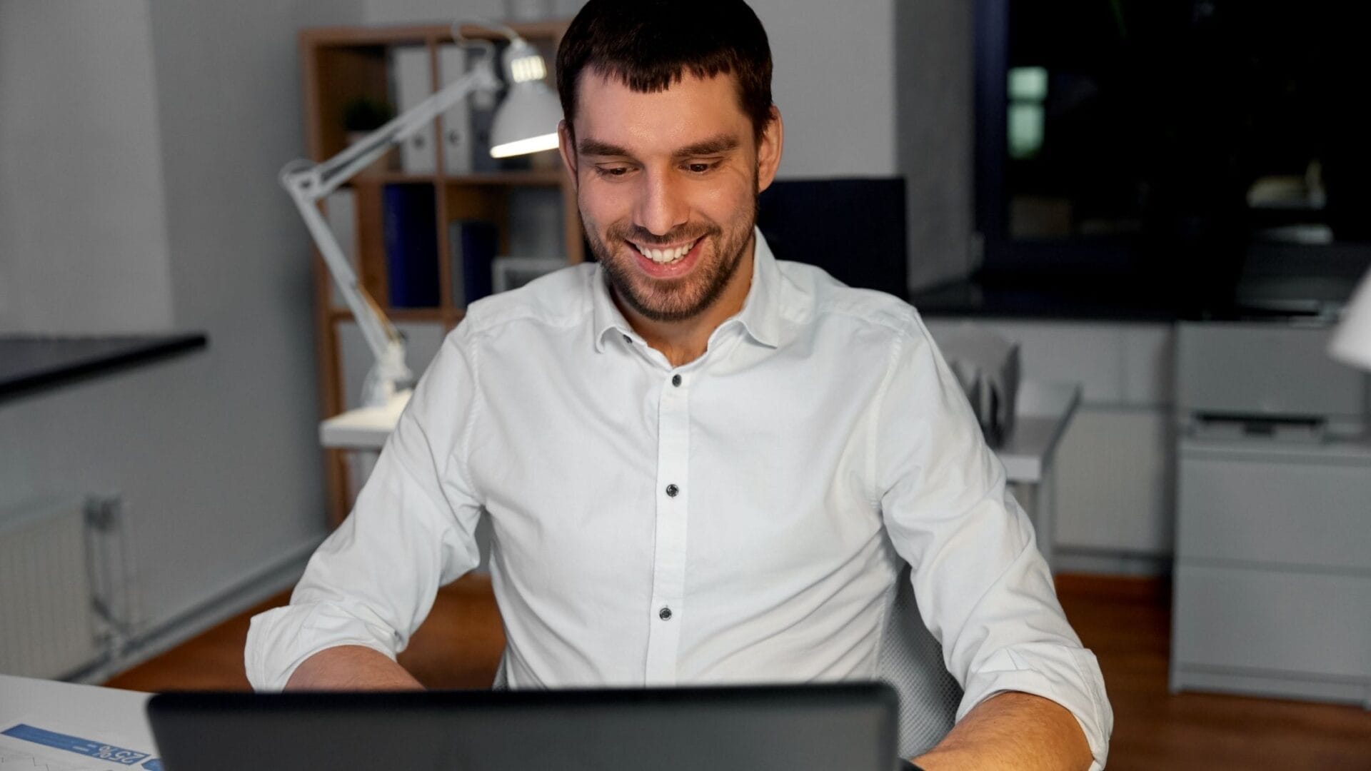 Proprietário sorrindo ao visualizar seus resultados no computador